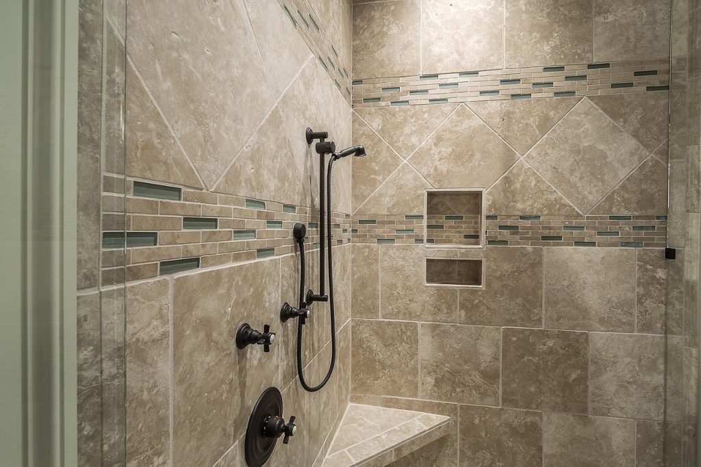 Moderne Dusche mit gefliesten Wänden, deren Fugen und Übergänge abgedichtet werden müssen
