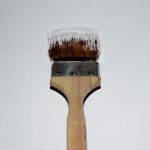 Maler beim Streichen von Wand und Decke mit Pinsel