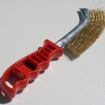 Stahlbuerste, mit der Rost von Metall entfernt wird